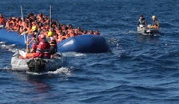 Bill (far right) accompanies the migrant boat with a partner rescue boat to a receiving vessel, where the migrants will be given medical attention, food, water, and shelter until they can be transferred to a transport vessel to Italy.